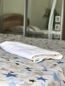 a white towel sitting on a bed in front of a mirror at 2-х кімн квартира в новобудові поблизу центру in Ternopilʼ