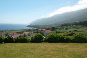 a view of a town with the ocean in the background at Casas da Figueira in São Roque do Pico