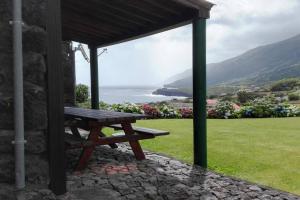 a wooden picnic bench sitting under a pavilion at Casas da Figueira in São Roque do Pico