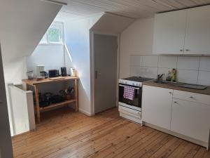 a kitchen with white cabinets and a stove top oven at Liten lägenhet 2 + 2 pers in Fågelfors
