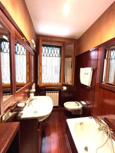 une grande salle de bains avec deux lavabos et deux miroirs dans l'établissement Rifugio alle Vele, à Venise