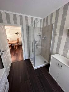 a bathroom with a shower and a wooden floor at Ferienwohnung Lobbe 2 - 100qm in Lobbe