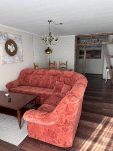 a living room with a red couch and a table at Ferienwohnung Lobbe 2 - 100qm in Lobbe