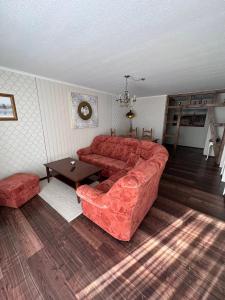 a living room with a red couch and a table at Ferienwohnung Lobbe 2 - 100qm in Lobbe