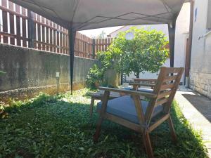 a patio with a table and a chair under an umbrella at Matija in Medulin +1 photo