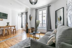 a living room with a couch and a table at MBA Splendide Appart - Montreuil 6 - Proches Vincennes in Montreuil