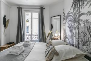 a bedroom with a large bed with towels on it at MBA Splendide Appart - Montreuil 6 - Proches Vincennes in Montreuil