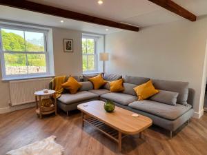 a living room with a couch and a table at Swartha Cottages in Silsden