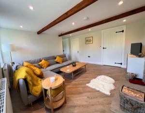 a living room with a couch and a table at Swartha Cottages in Silsden