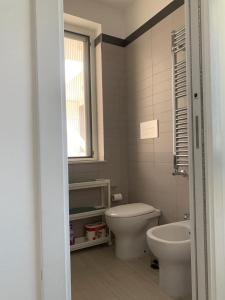 a bathroom with a toilet and a sink and a window at Casa vacanze in Volla