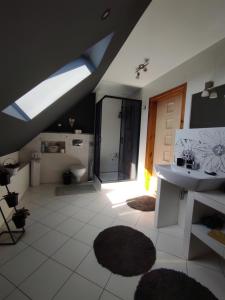 een badkamer met een wastafel, een toilet en een dakraam bij Przyjazny Domek in Tarnowskie Góry