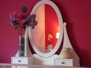 a mirror on top of a white table with flowers at Flower Pot Complex Suites! in Preveza