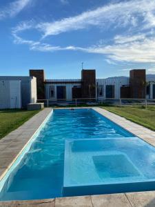 une grande piscine bleue en face d'un bâtiment dans l'établissement Posada Patagonia Bed & Breakfast, à San Juan