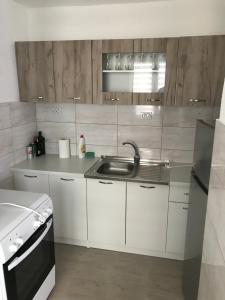 ヴィシェグラードにあるApartmani Golubina - Visegradのシンクとコンロのある白いキッチン