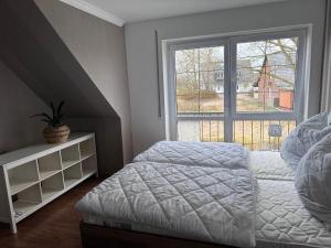 een slaapkamer met een bed en een groot raam bij Ferienwohnung Lobbe 1 - 120qm in Lobbe