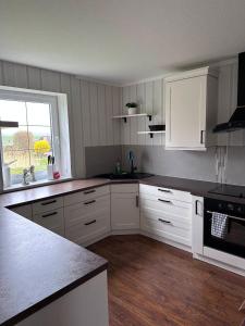 a kitchen with white cabinets and a counter top at Ferienwohnung Lobbe 1 - 120qm in Lobbe