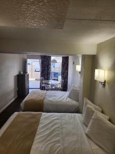 um quarto de hotel com duas camas e uma mesa em Yankee Clipper Resort Motel em Wildwood Crest