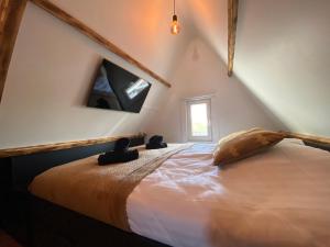 a bedroom with a large bed with a tv on the wall at The island life beach house 1 in De Koog
