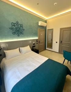 una camera con un grande letto bianco e una sedia di Richmond Hotel a Chişinău
