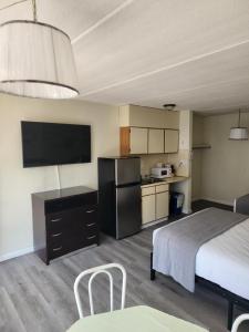 een hotelkamer met een bed en een keuken met een televisie bij Yankee Clipper Resort Motel in Wildwood Crest