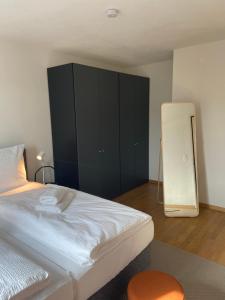 a bedroom with a large bed and a black cabinet at 1 BDR Apartment in Zurich West in Zürich