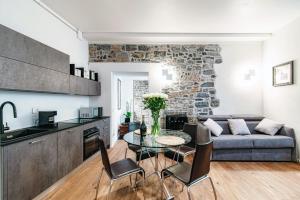 cocina y sala de estar con mesa y sofá en Suite Lo Storico - The House Of Travelers, en Como