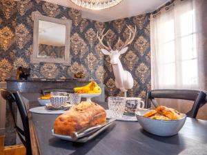 a table with food and a deer head on the wall at La CHAMBRE BLEUE in Lézat-sur-Lèze