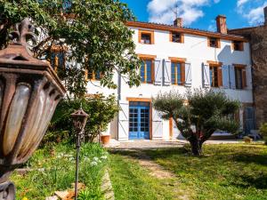 an exterior view of a white house with a blue door at La CHAMBRE BLEUE in Lézat-sur-Lèze