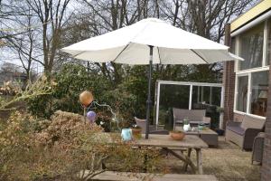stół z parasolem na patio w obiekcie Vakantie Accommodatie Egelantier w mieście Dwingeloo