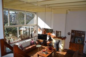 a living room with a couch and a large window at Vakantie Accommodatie Egelantier in Dwingeloo