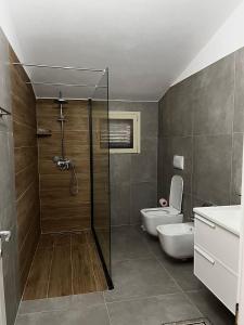 a bathroom with a shower and a toilet and a sink at Albanian Traditions Legacy in Durrës