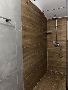 y baño con ducha y paredes de madera. en Albanian Traditions Legacy, en Durrës