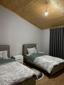 a bedroom with two beds and a window at Albanian Traditions Legacy in Durrës