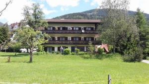 una casa grande con un campo delante en Gästehaus Post Aigner, en Greifenburg