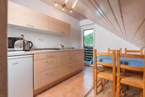 a kitchen with wooden cabinets and a table and chairs at Apartments Žnidar in Bohinj