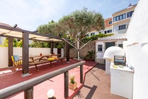 a patio with a table and a tree on it at BeGuest Cascais Casa da Tia Marta in Cascais