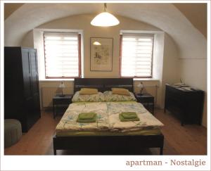 ヴェセリー・ナト・モラヴォウにあるApartmán U Kostelaのベッドルーム1室(ベッド1台、テーブル2台、窓2つ付)
