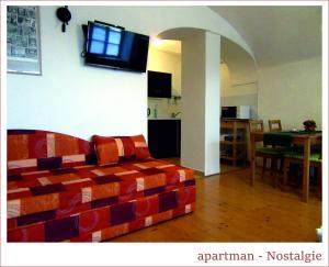 a living room with a couch and a television on the wall at Apartmán U Kostela in Veselí nad Moravou