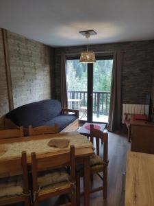een woonkamer met een tafel en een bank bij Appartement VALFRÉJUS pied des pistes 4-6 personnes Chalet Thabor in Modane