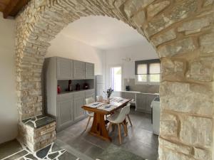 a kitchen with a table and a stone wall at Villa Ambelas - Traditional House in Ambelas