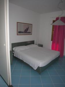 1 dormitorio con cama blanca y cortina rosa en Residence Le Terrazze en Olbia