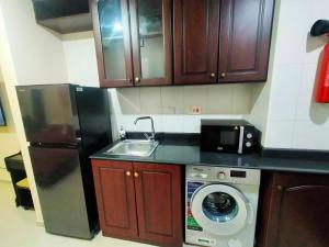 a kitchen with a refrigerator and a washing machine at Sea View Studio 5 Royal Breeze سي ويو ستوديو رويال بريز in Ras al Khaimah
