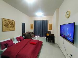 a bedroom with a bed and a tv on a wall at Sea View Studio 5 Royal Breeze سي ويو ستوديو رويال بريز in Ras al Khaimah