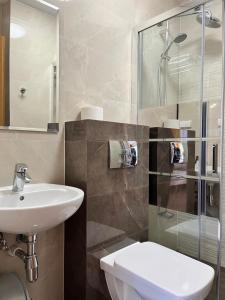 a bathroom with a sink and a toilet and a shower at Pokoje Gościnne U RYBAKA in Karwia