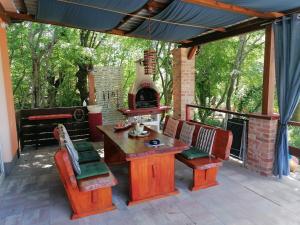 patio ze stołem, krzesłami i kuchenką w obiekcie The Forest House Krk 2 w mieście Kras