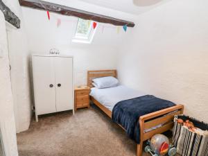 a bedroom with a bed and a cabinet and flags at Sweetholme in Caernarfon
