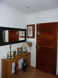 a room with a wooden table and a mirror at Quinta Nova Guest Room in Odivelas