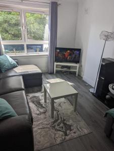 a living room with a couch and a coffee table at Ann St Vacation Apartment Greenock United Kingdom in Greenock