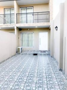 洛馬斯德薩莫拉的住宿－Casa entera con patio, parrilla y cochera，一座拥有石头地板和阳台的建筑