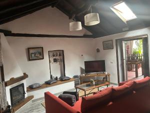 Una sala de estar con un sofá rojo y una chimenea. en Casa Lucia, en Genovés
